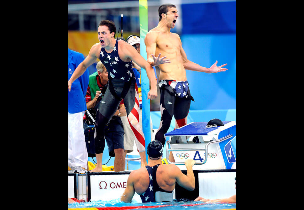 BEIJING, CHINA AUGUST 11TH, 2008--USA' Garrett Weber-Gale, left, and Michael Phelps celebrate with Jason Lezak, in the pool, the gold medal in the 4x100 Freestyle Relay at the 2008 Beijing Olympics.